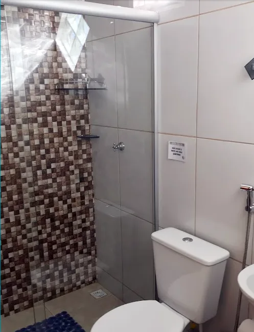 Banheiro privativo com pastilhas e box de vidro