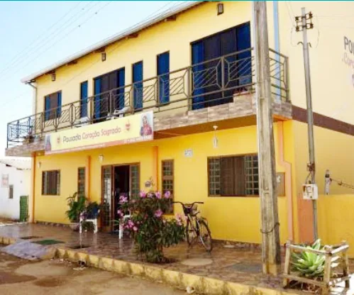 Cozinha compartilhada com bancada preta e geladeira grande