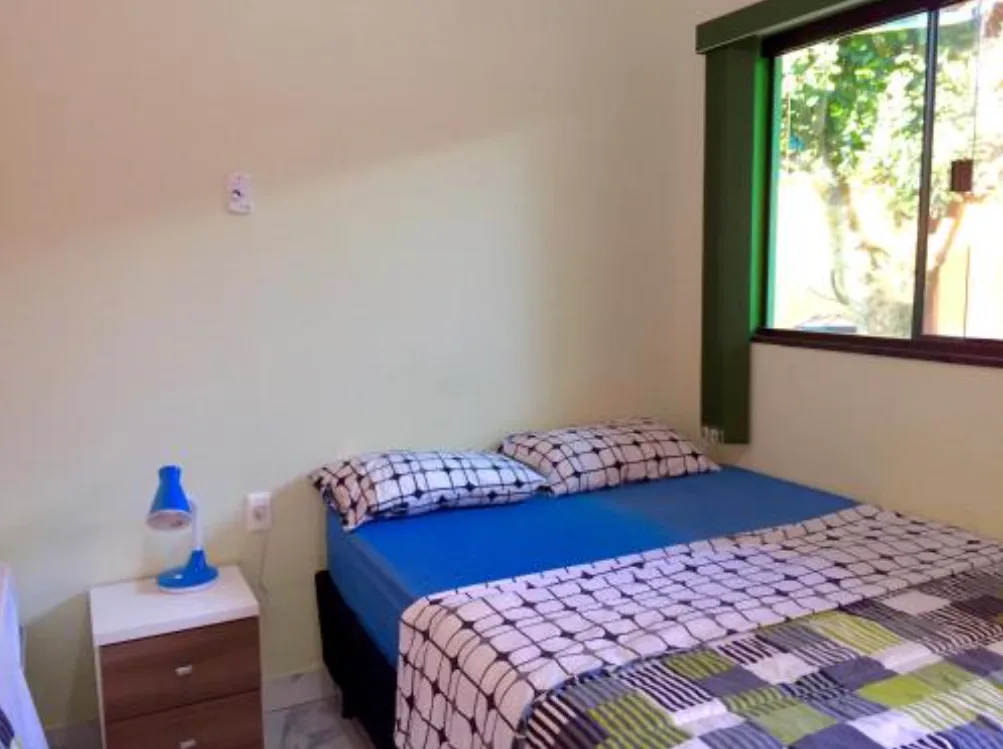 Quarto de casal com parede em degradê verde sálvia e abajur