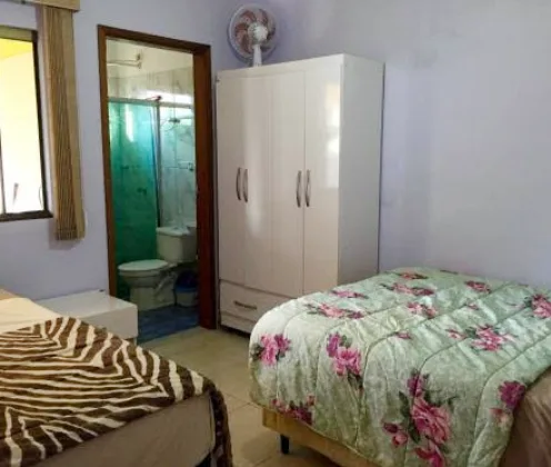Quarto duplo com cama de casal, cama de solteiro, ventilador e suíte