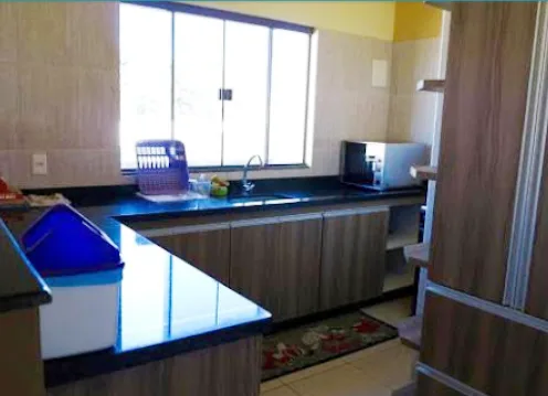 Sala de estar compartilhada com sofá e cozinha integrada